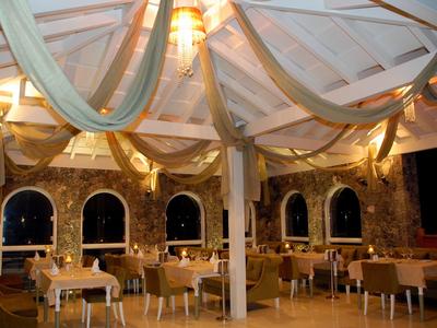 Gemütlicher Außenbereich eines Restaurants mit dekorativem Stoffdach und Beleuchtung bei Nacht.