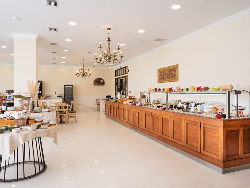Bright buffet area with wooden counters and dining tables in a spacious room.