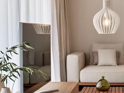 Modernes Wohnzimmer mit beige Sofa, hölzernem Tisch, grünem Glasdekor und großer Spiegelwand.