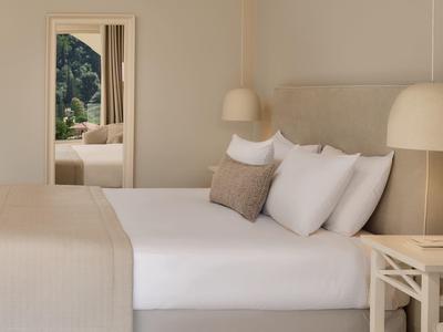 Helles, gemütliches Schlafzimmer mit großem Bett und Zugang zu Balkon mit Bergblick.