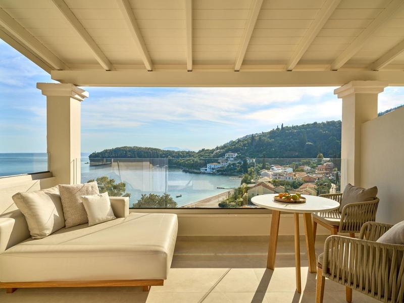 Überdachte Terrasse mit bequemer Lounge, Sitzmöbeln und Blick auf die Küste und das Meer.