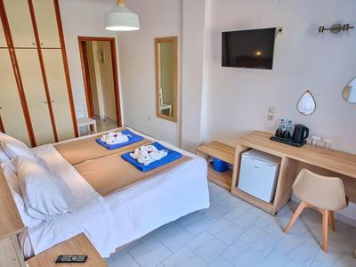 Helles Hotelzimmer mit Doppelbett, Schreibtisch, TV und Minibar in modernem Design.