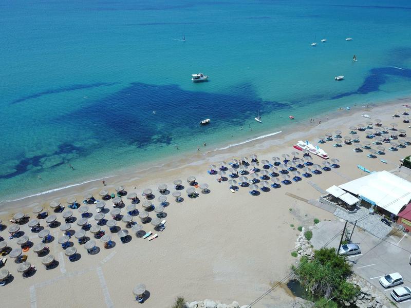 Strand mit Reihen von Sonnenschirmen und klarem blauem Wasser am Hotelmeer.