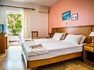 Helles Hotelzimmer mit zwei Einzelbetten, Balkon und gemütlicher Einrichtung.