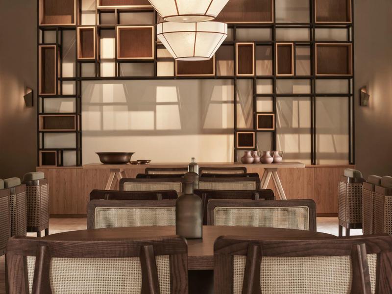 Elegantní jídelna s dřevěnými židlemi a dekorativními policemi na zdi.