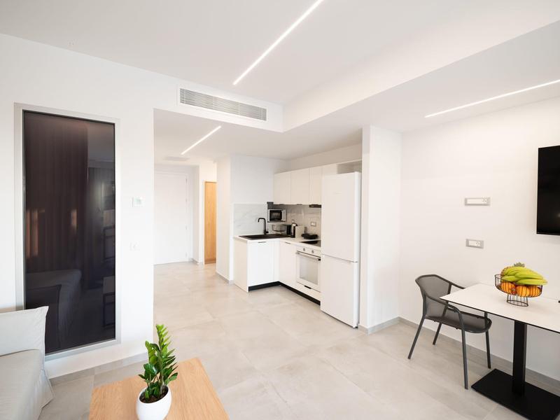 Cucina moderna e luminosa con zona pranzo in un appartamento con design minimalista.