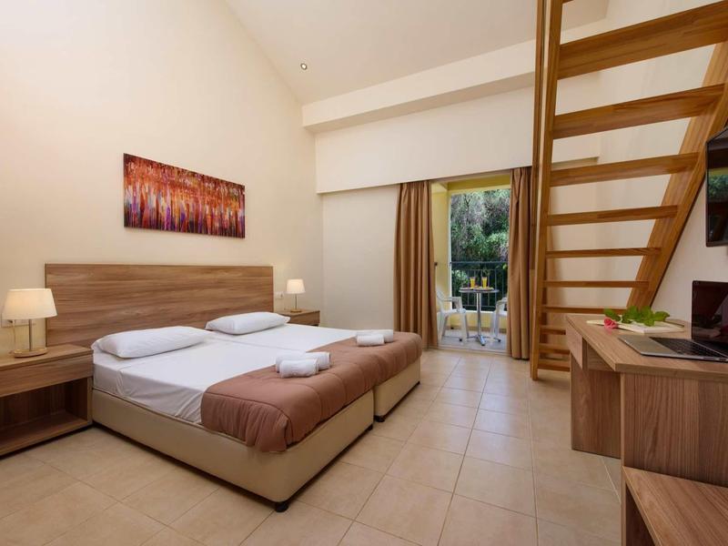 Modernes Hotelzimmer mit Doppelbett, Holzmöbeln, Flachbildschirm und Balkon mit Aussicht.