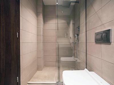 Moderne doucheruimte met glazen wand en beige betegelde muren in een badkamer.