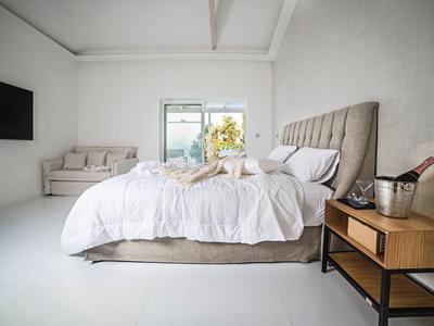 Moderne slaapkamer met groot bed en sofa, helder en minimalistisch ingericht