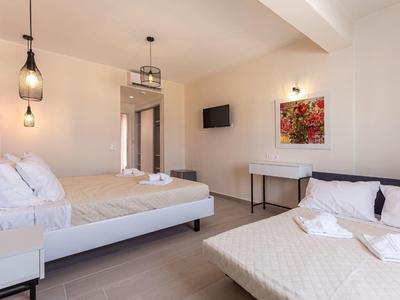 Moderní hotelový pokoj se dvěma postelemi, minimalistickým zařízením a teplým osvětlením.