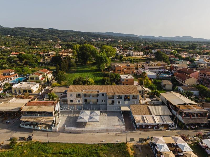 Letecký pohled na malé město s centrálním náměstím a okolními budovami v zelené krajině.