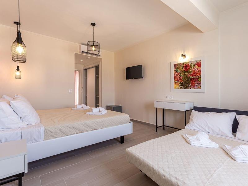 Moderní hotelový pokoj se dvěma postelemi, minimalistickým zařízením a teplým osvětlením.