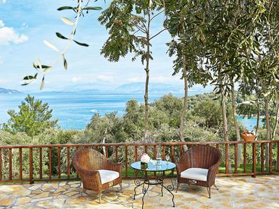 Terras met twee stoelen en tafel met uitzicht op zee en bomen