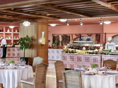 Restaurant élégant avec tables dressées, buffet et plafond en bois chaleureux.