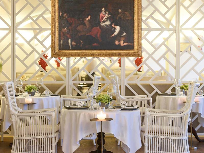 Table à manger élégante avec chaises blanches et serviettes pliées artistiquement dans un restaurant de luxe.