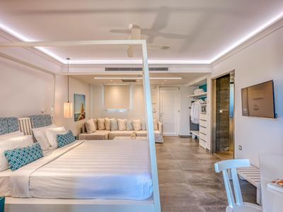 Helles Hotelzimmer mit Doppelbett, Sitzecke, Schreibtisch und modernem Dekor.