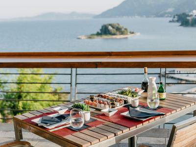 Table dressée avec boissons et snacks sur balcon avec vue sur la mer