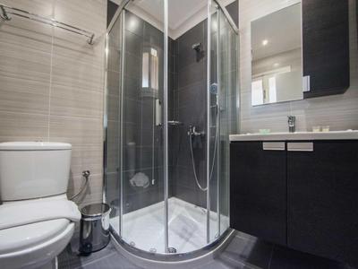 Bagno moderno con cabina doccia, toilette e mobile lavabo nero.