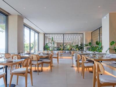 Restaurante moderno y luminoso con muebles de madera y vista a la naturaleza