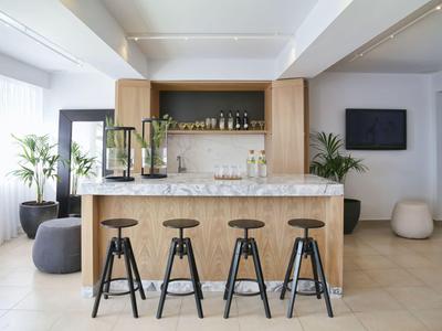 Modern hotel bar area with four stools and minimalist design.
