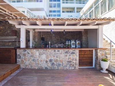 Espace extérieur moderne avec bar en pierre, accents en bois et escalier adjacent dans un hôtel.