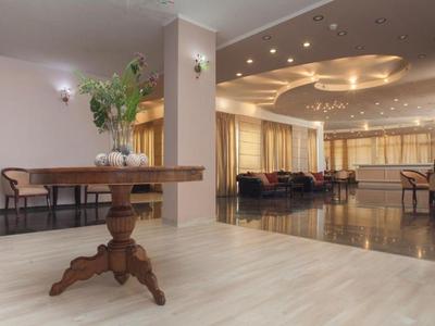 Hall élégant avec décor en bois, arrangements floraux et coin salon spacieux avec canapés.