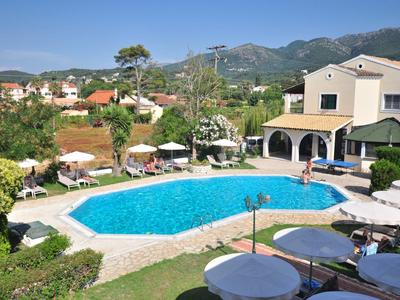 Großer blauer Pool mit Sonnenschirmen, Liegen und einem Haus in bergiger Landschaft.