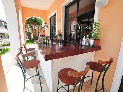 Barhoek met krukken op een terras in warme oranje tinten.