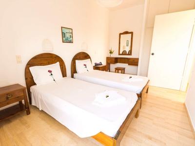 Camera con due letti singoli, mobili in legno e arredamento semplice.