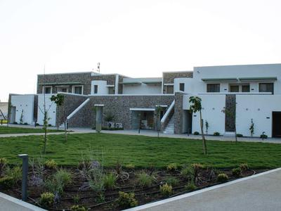 Modernes zweistöckiges Hotelgebäude mit weißem und grauem Design und gepflegtem Vorgarten.