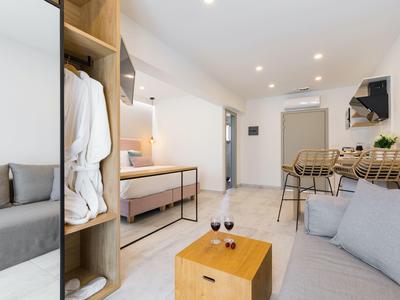 Modern eingerichtetes Wohnzimmer mit grauen Sofas, Holzmöbeln und gedeckten Farbtönen.