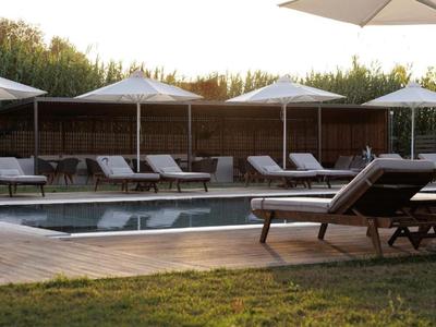 Pool area with lounge chairs and umbrellas in a quiet garden