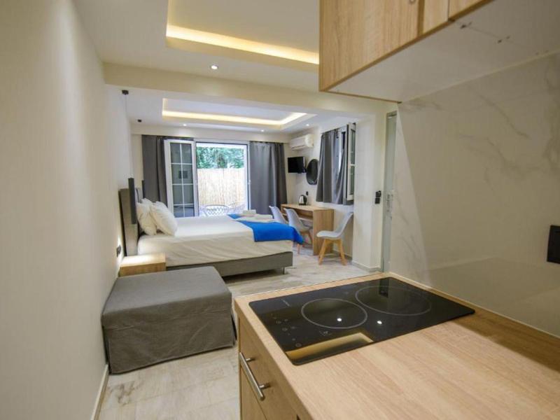 Chambre d'hôtel moderne avec kitchenette, lit et balcon.