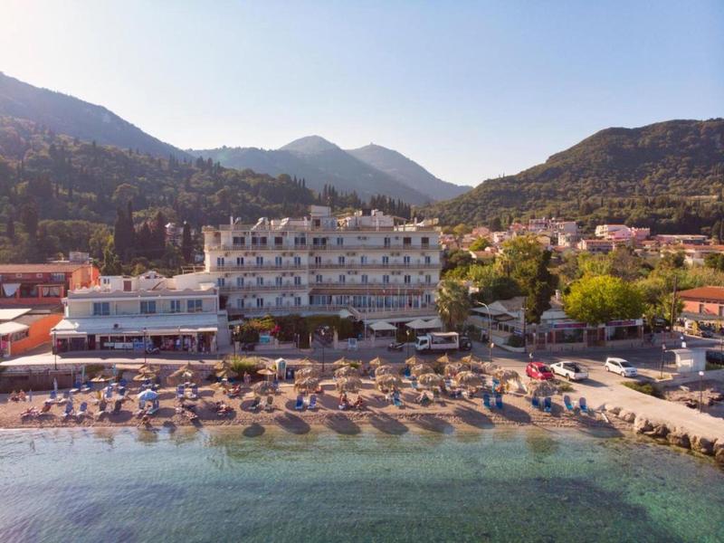 Hôtel sur la plage avec transats et montagnes en arrière-plan