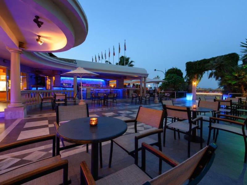 Espace extérieur d'hôtel moderne avec tables et chaises au crépuscule.