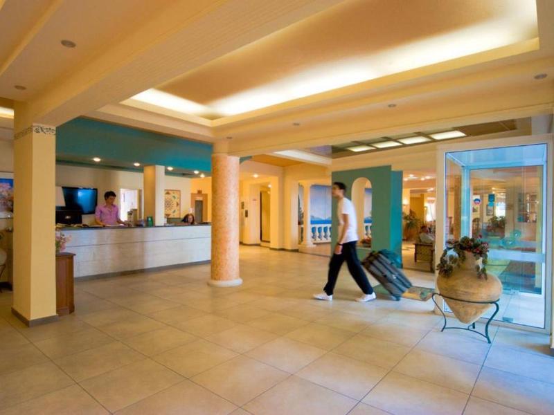 Hall d'hôtel spacieux avec réception et un client avec bagages