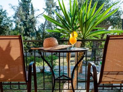 Deux chaises et une table avec un chapeau de paille et un cocktail dans un jardin avec des palmiers