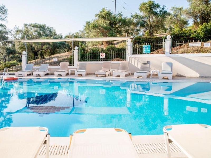 Piscine extérieure moderne avec chaises longues et parasols dans un cadre tranquille.