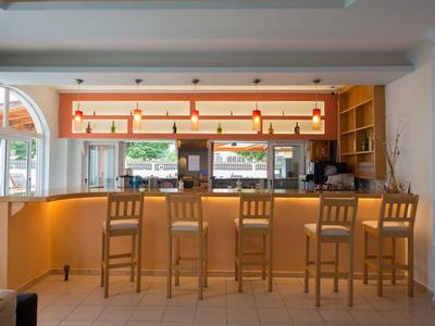 Bright bar with four wooden stools and large windows overlooking a terrace.