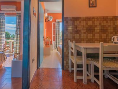 Uitzicht op een vakantieappartement met een kleine eettafel, keuken en terrasdeur