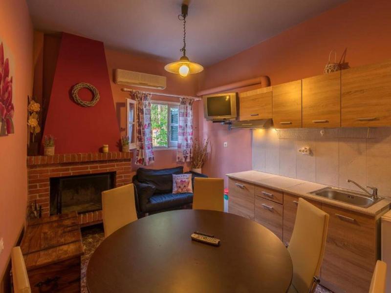 Gezellige keuken- en eetruimte met open haard en houten kasten in warme tinten