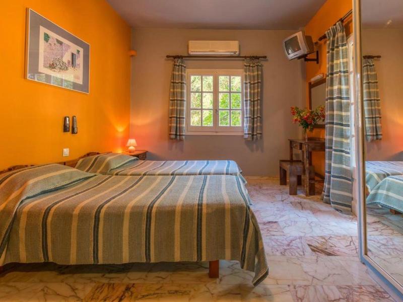 Gezellige kamer met tweepersoonsbed, oranje muren en marmeren tegelvloer.