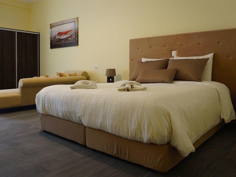 Pohodlný hotelový pokoj se dvěma postelemi, tmavou podlahou a obrazem na zdi.