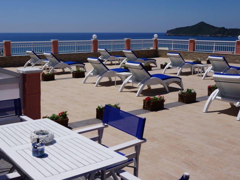 Terasa s lehátky a stoly s výhledem na moře a ostrov v pozadí