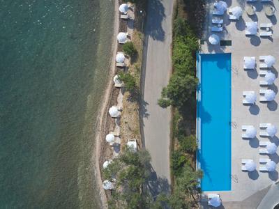 Bird's-eye view of a hotel with pool next to the sea and a path in between