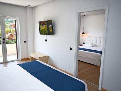 Modern ingerichte hotelkamer met toegang tot een balkon en een aangrenzende slaapkamer.