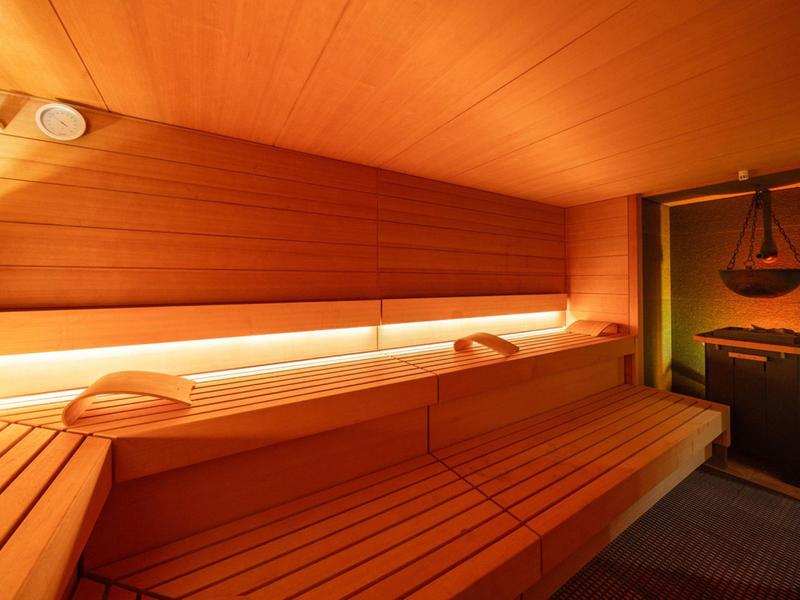 Warmer, gemütlicher Saunaraum mit Holzverkleidung und indirekter Beleuchtung.