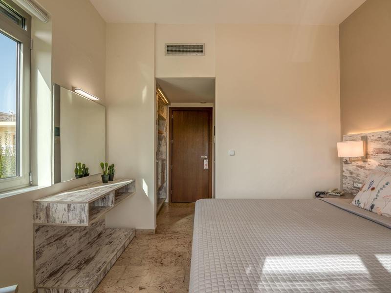 Chambre lumineuse et moderne avec grande fenêtre et intérieur simple.