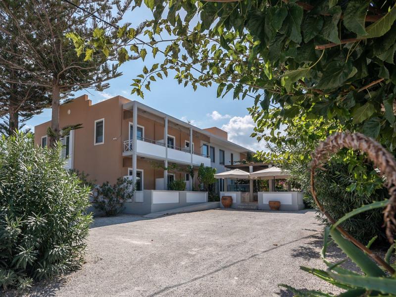 Hôtel à plusieurs étages avec chambres avec balcon et grande terrasse entourée de plantes vertes