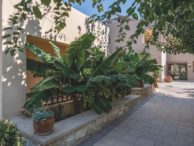 Moderner Gebäudekomplex mit Pflanzen und Schatten auf einem gepflasterten Innenhof